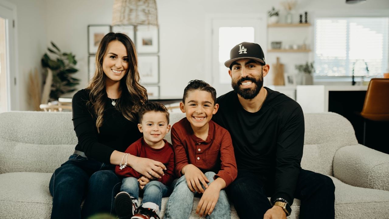 Family of four sitting on a couch, smiling