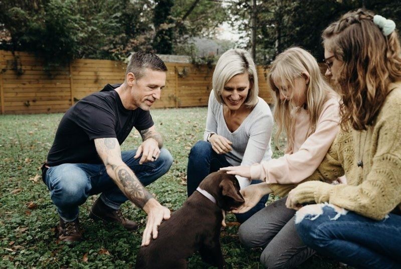 Group of people petting a puppy
