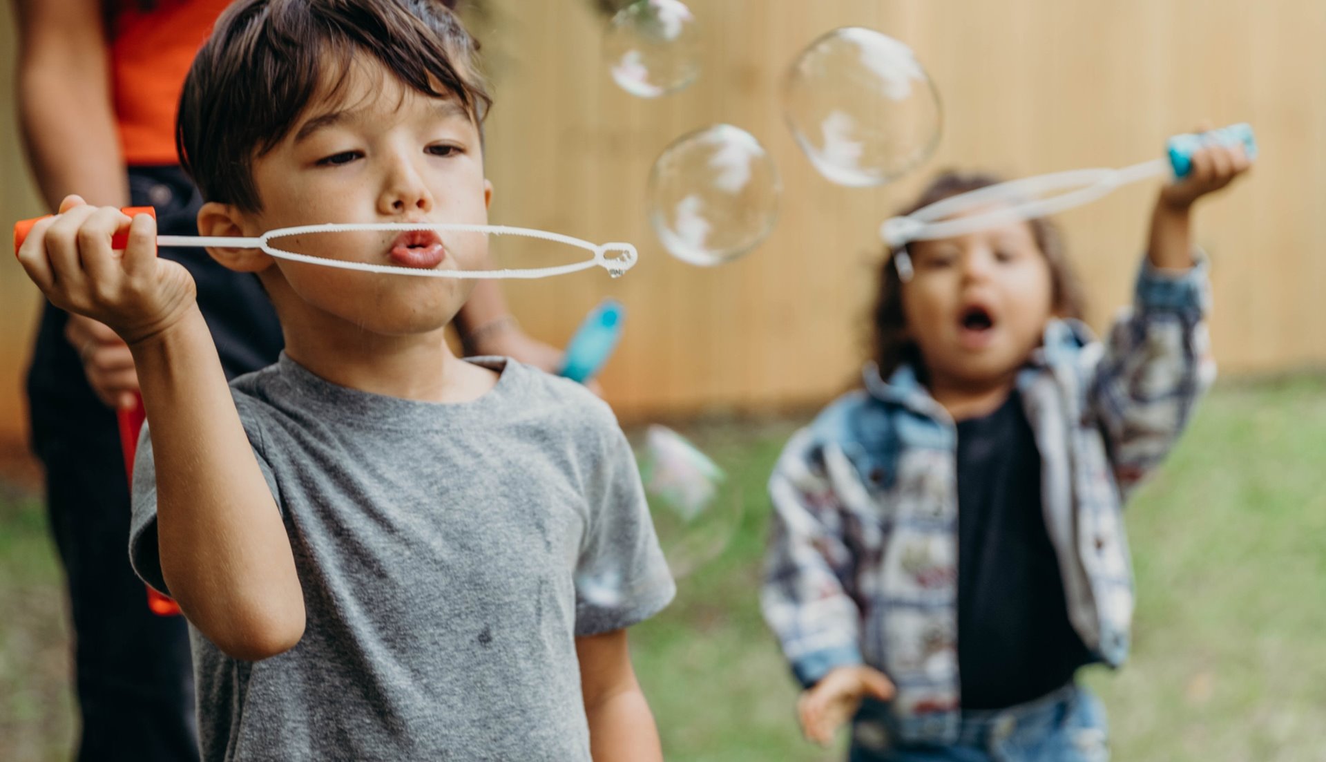 Kids blowing bubbles using bubble wands
