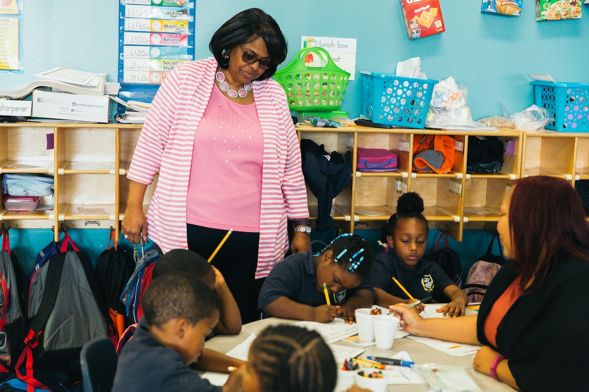 Cheryl Turner (left) watches Sugar Creek Charter kindergarteners complete an activity led by their teacher, Anquinette Marsh (far right).