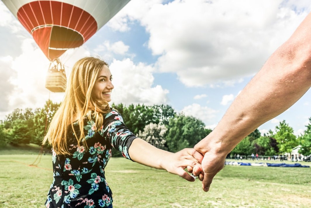 Couple holding hands, air balloons