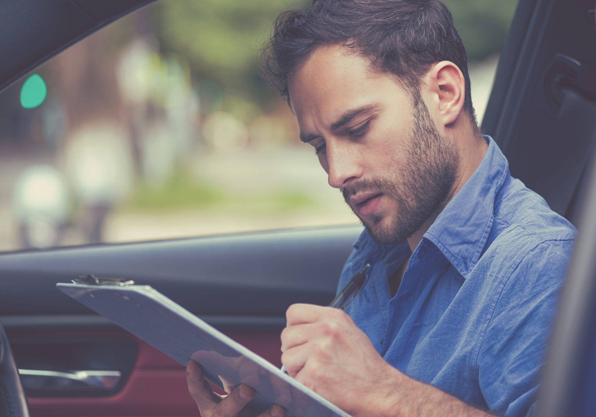 Man inside new car reading signing documents