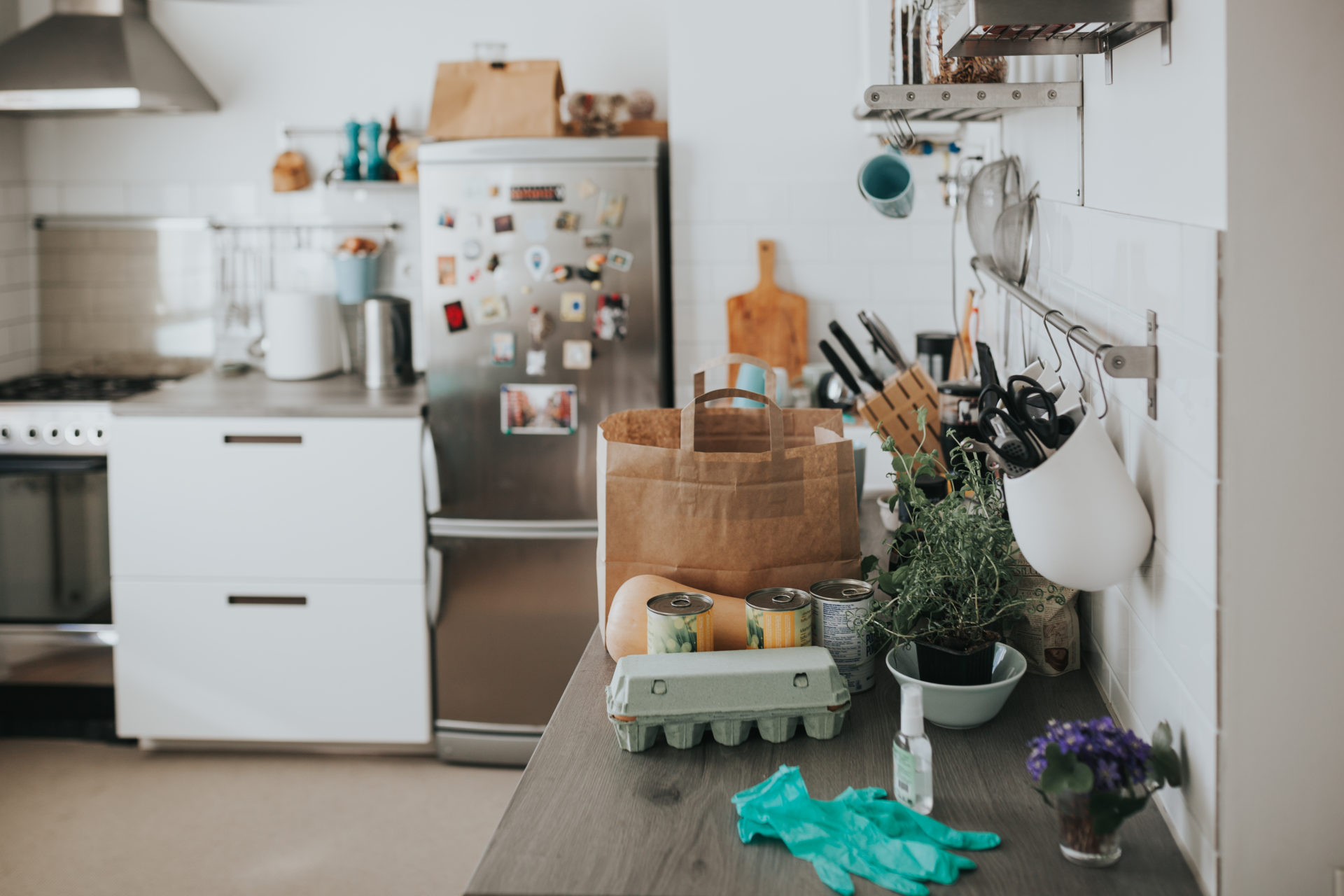 Kitchen counter with groceries, protective gloves and disinfectant spray