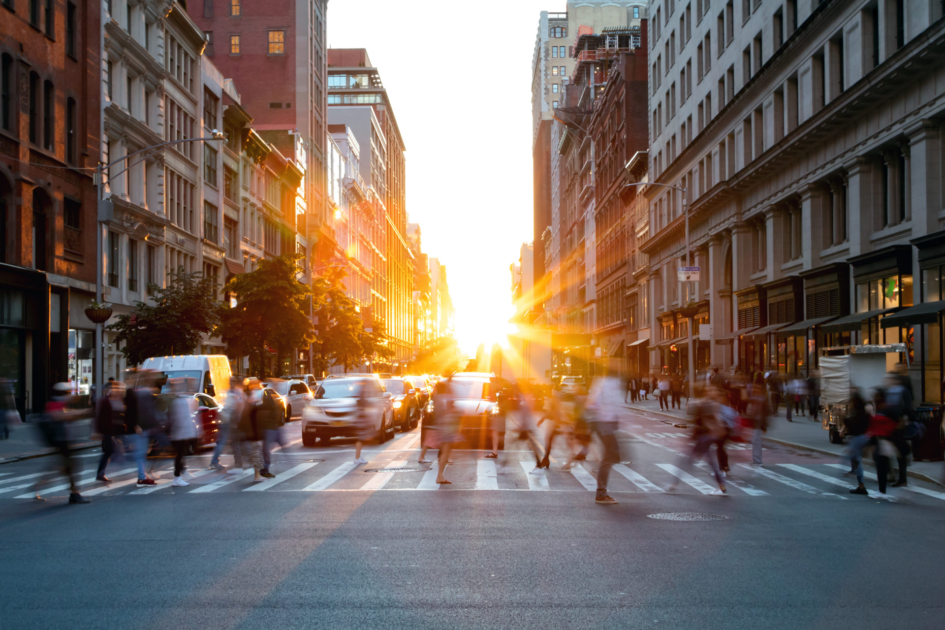 Crowds of busy people walking through the intersection of 5th Avenue and 23rd Street in Manhattan, New York City