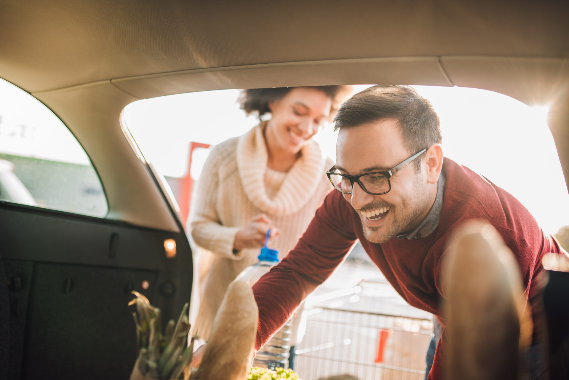 Couple putting groceries in a car