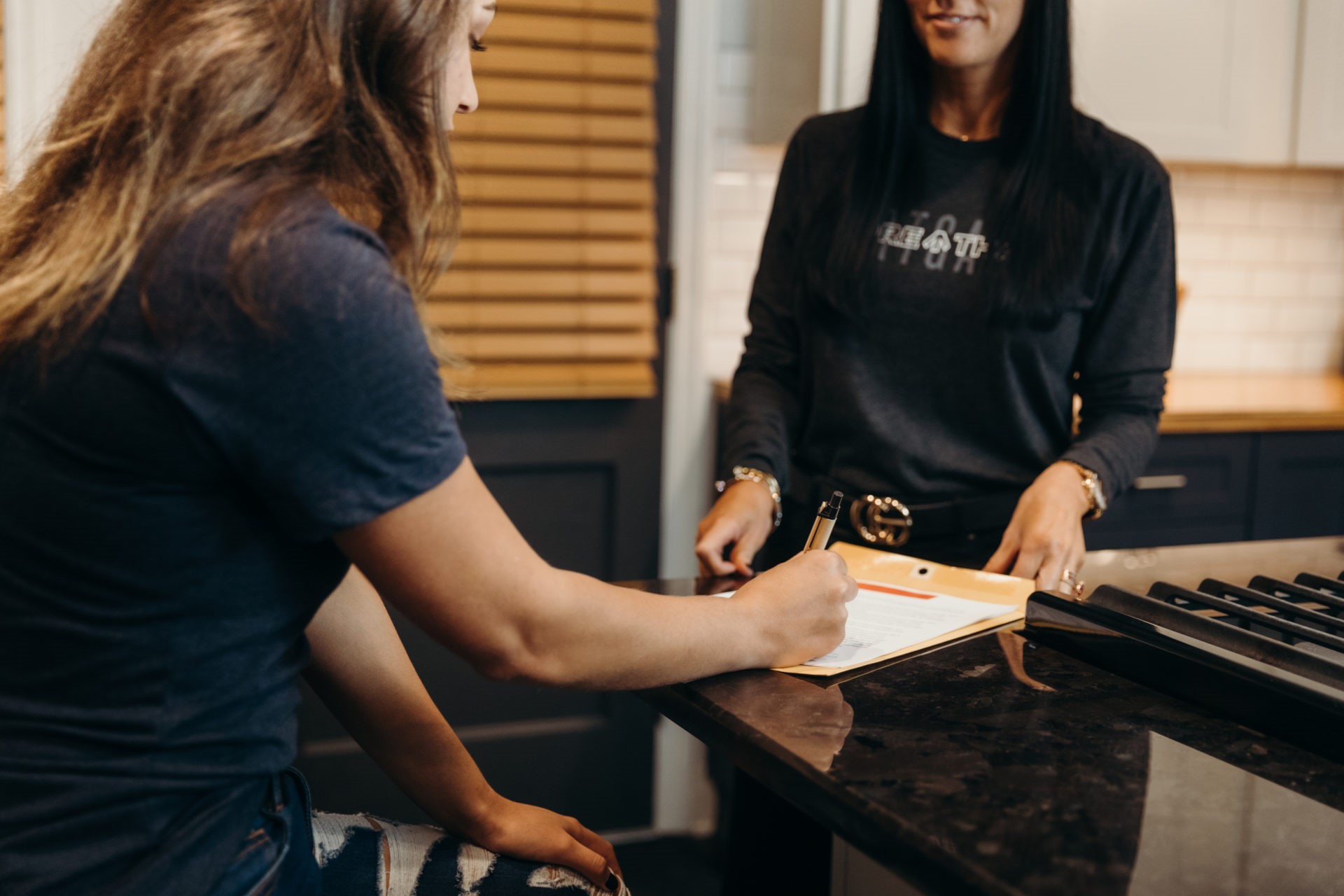 A woman sign some documents in the kitchen