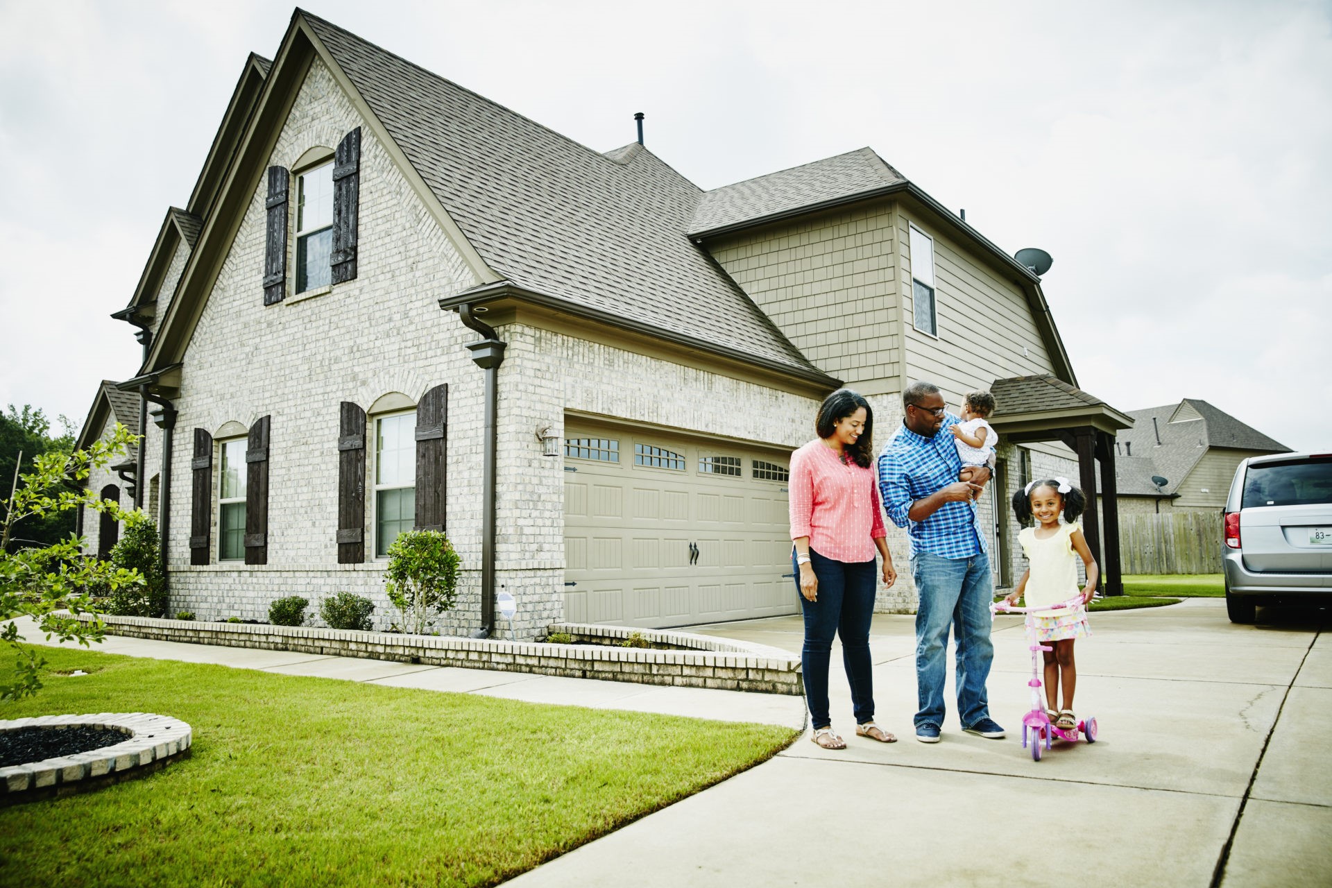 Portrait of family in driveway in front of home