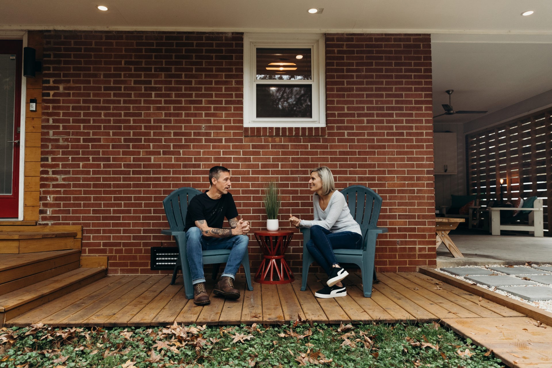 Couple sitting in front of their brick house