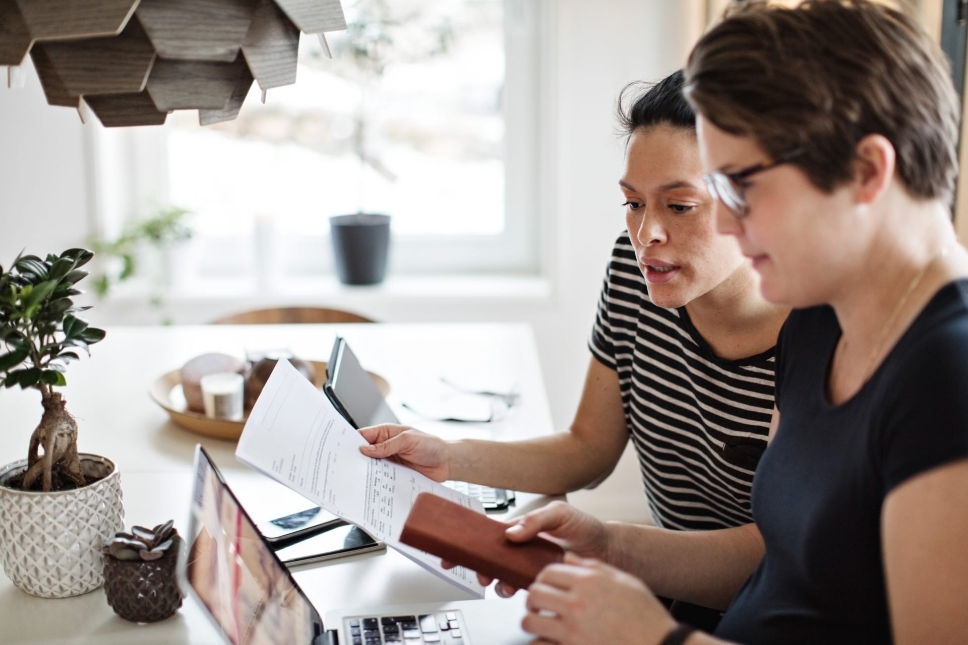 Lesbian couple discussing over financial bills while using laptop at table