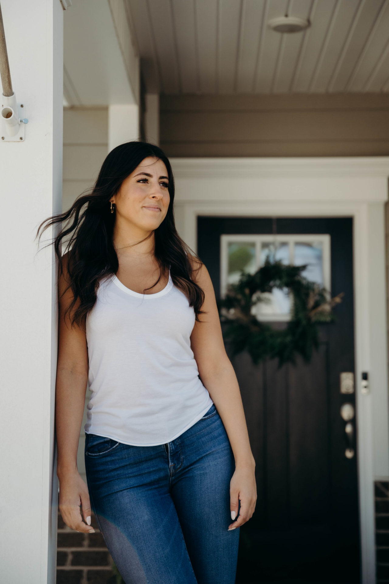 Woman in white tank standing outside