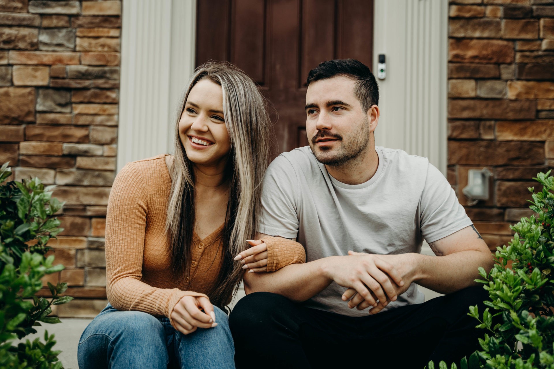 A couple sitting outside their house