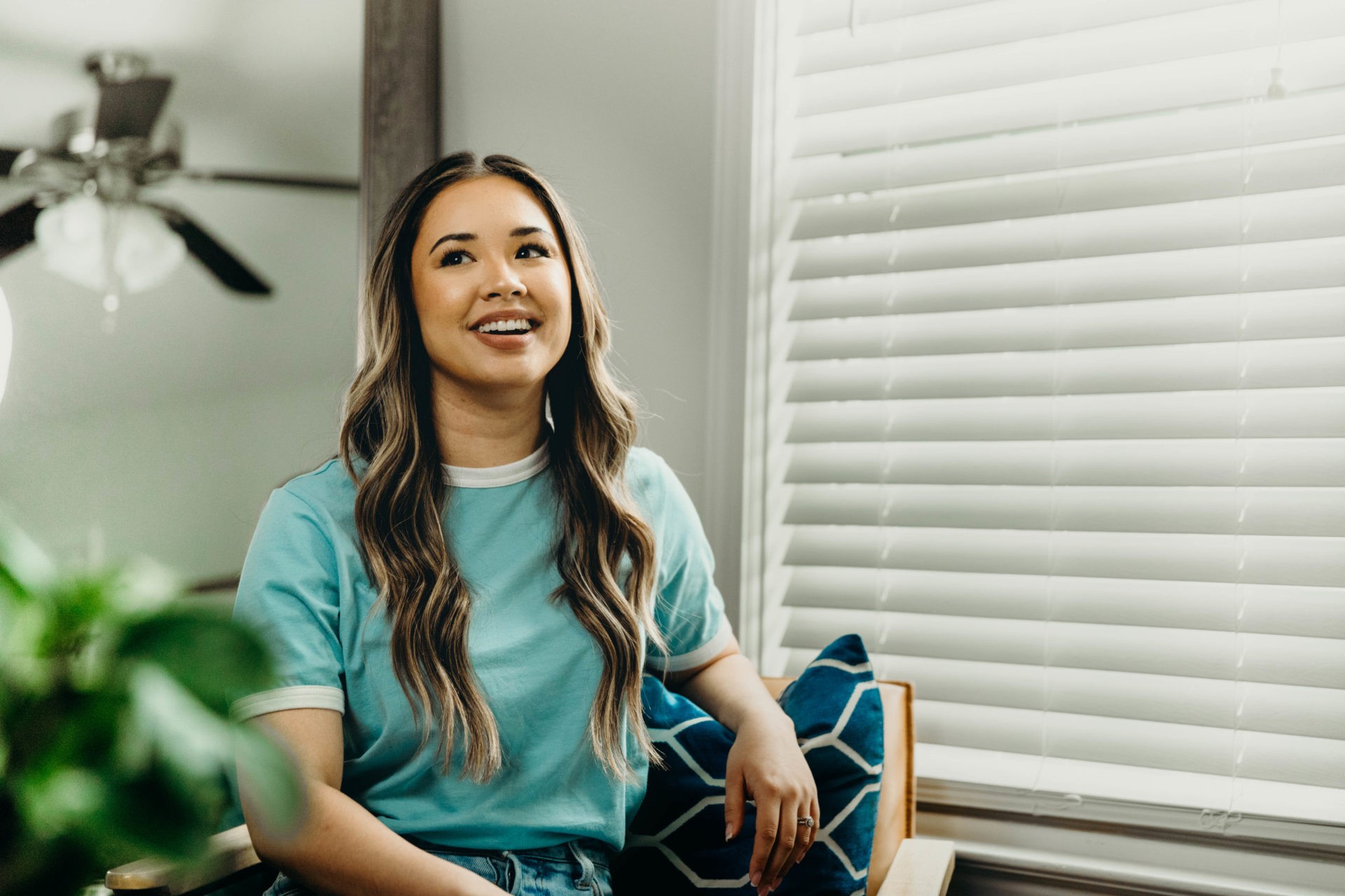 Woman in light blue top and jeans sitting down