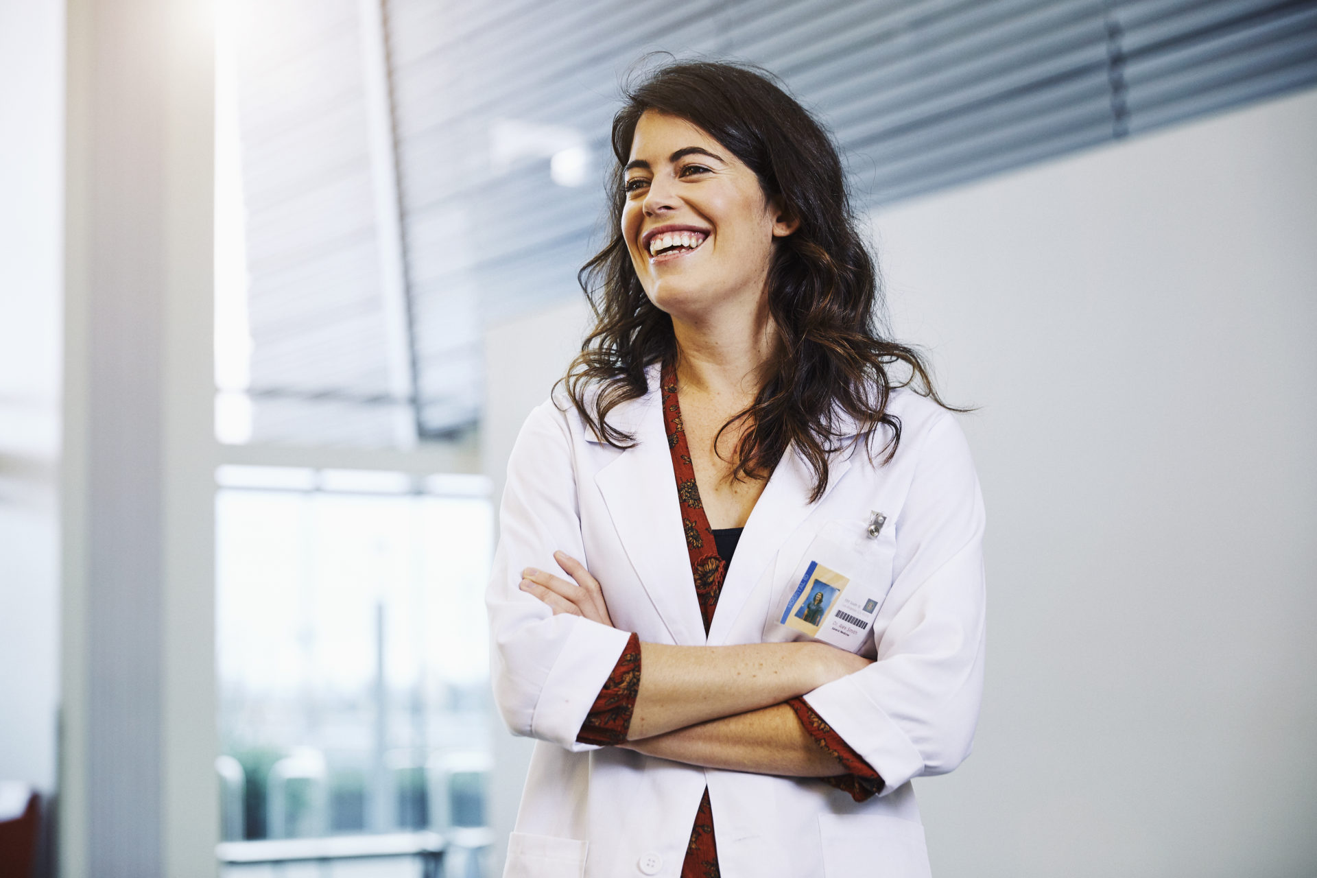 Confident female doctor with arms crossed standing in hospital