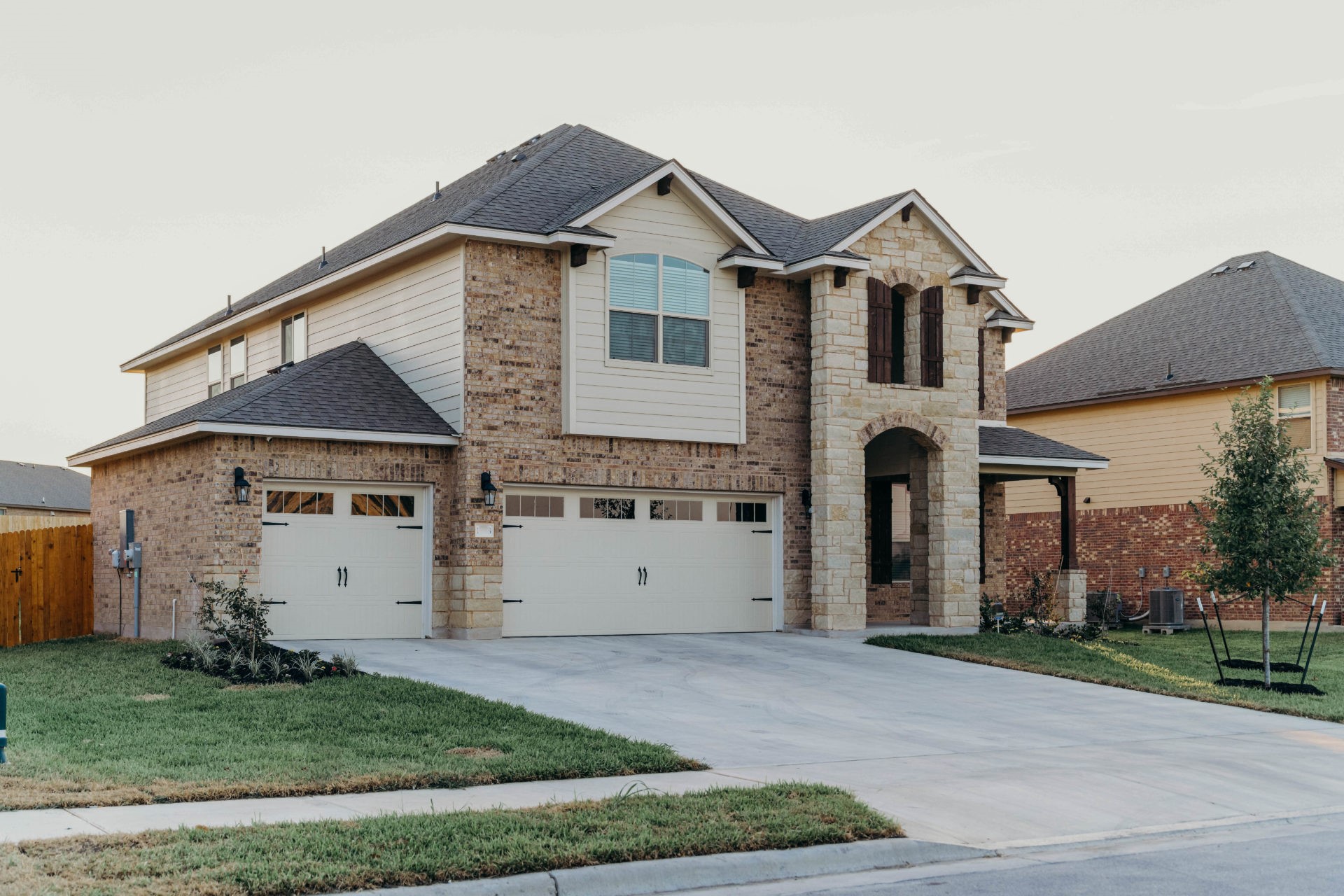 A large traditional two story house with two garage doors