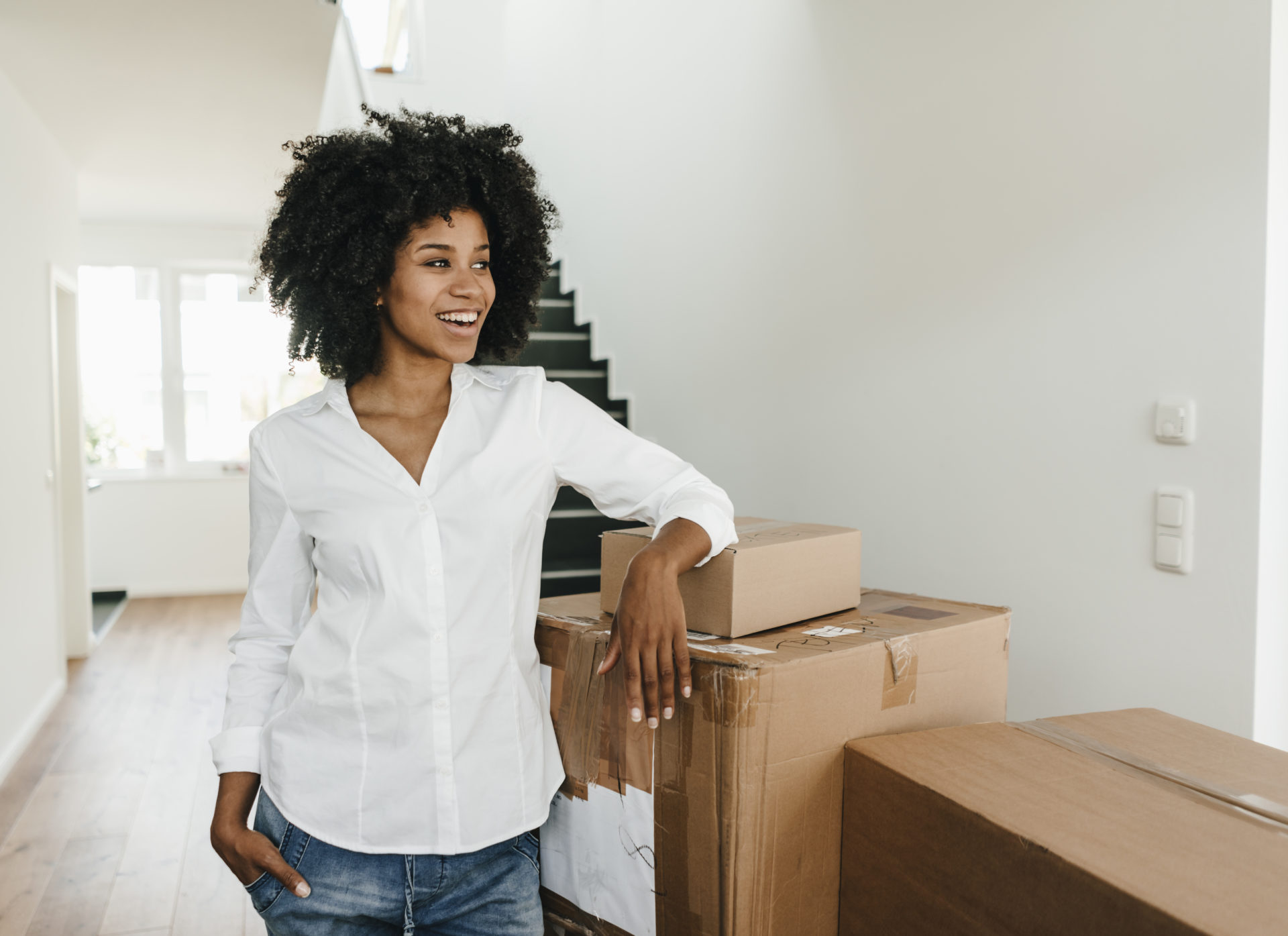 Smiling young woman with cardboard boxes