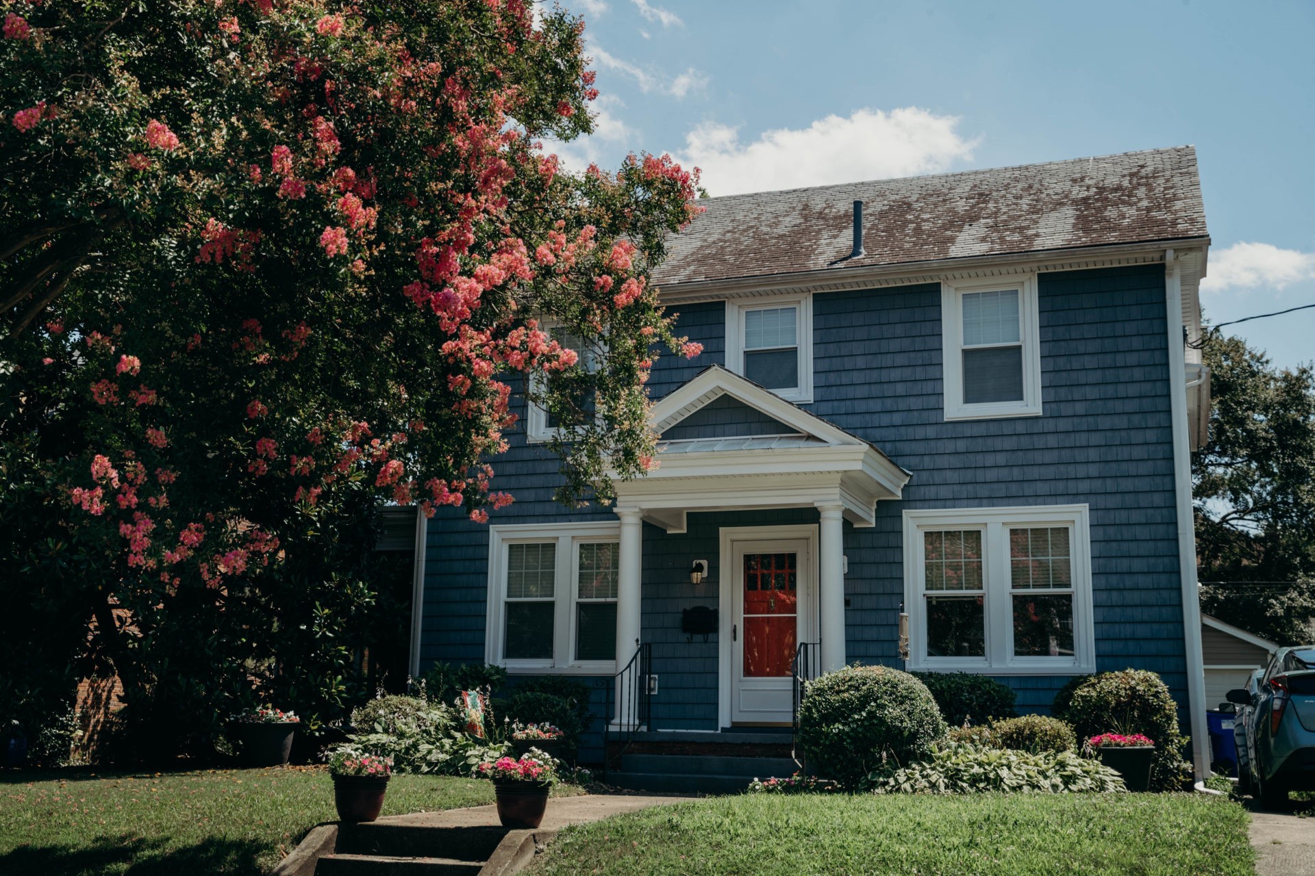 Two story blue home with red door