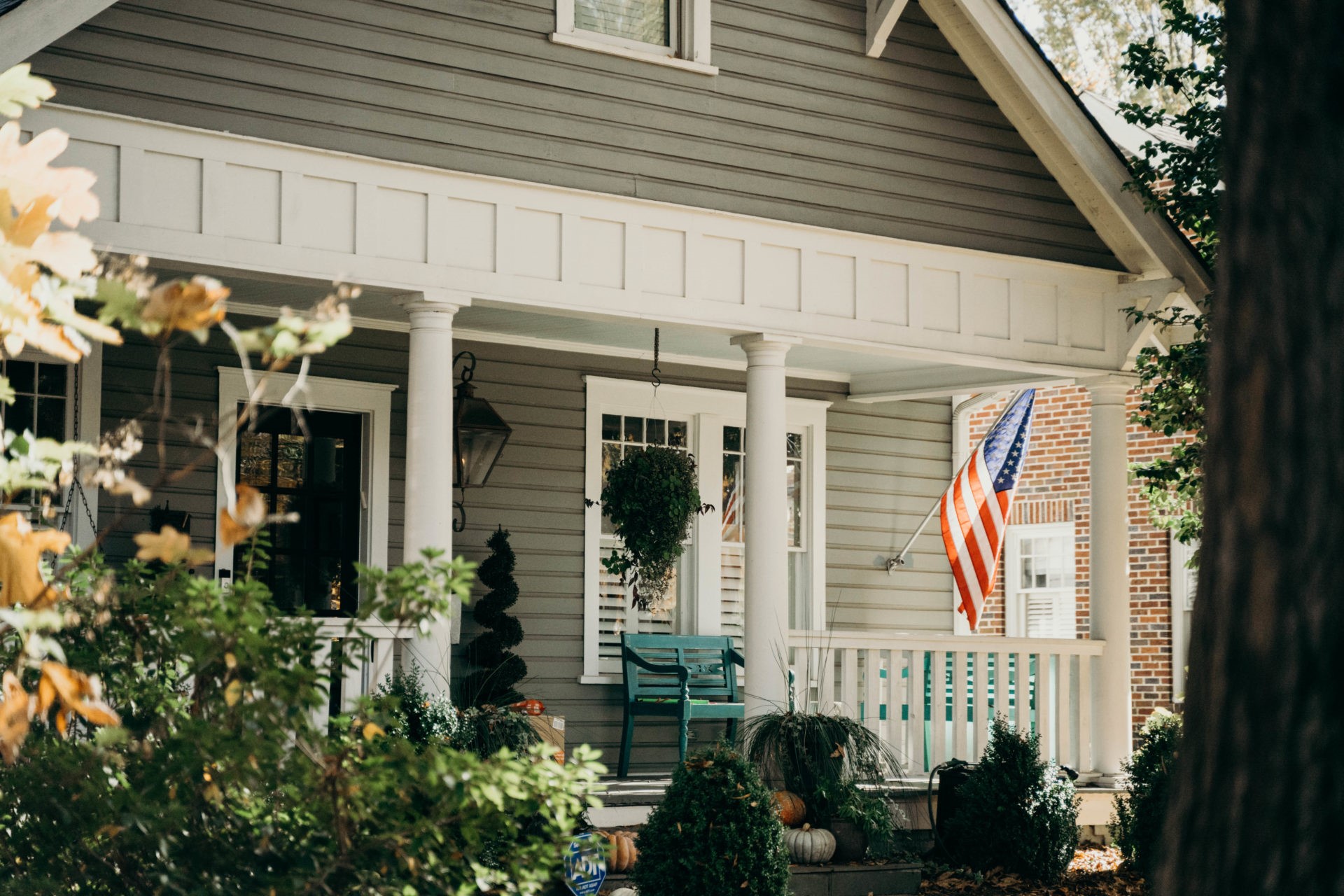 Green one story home with an American flag