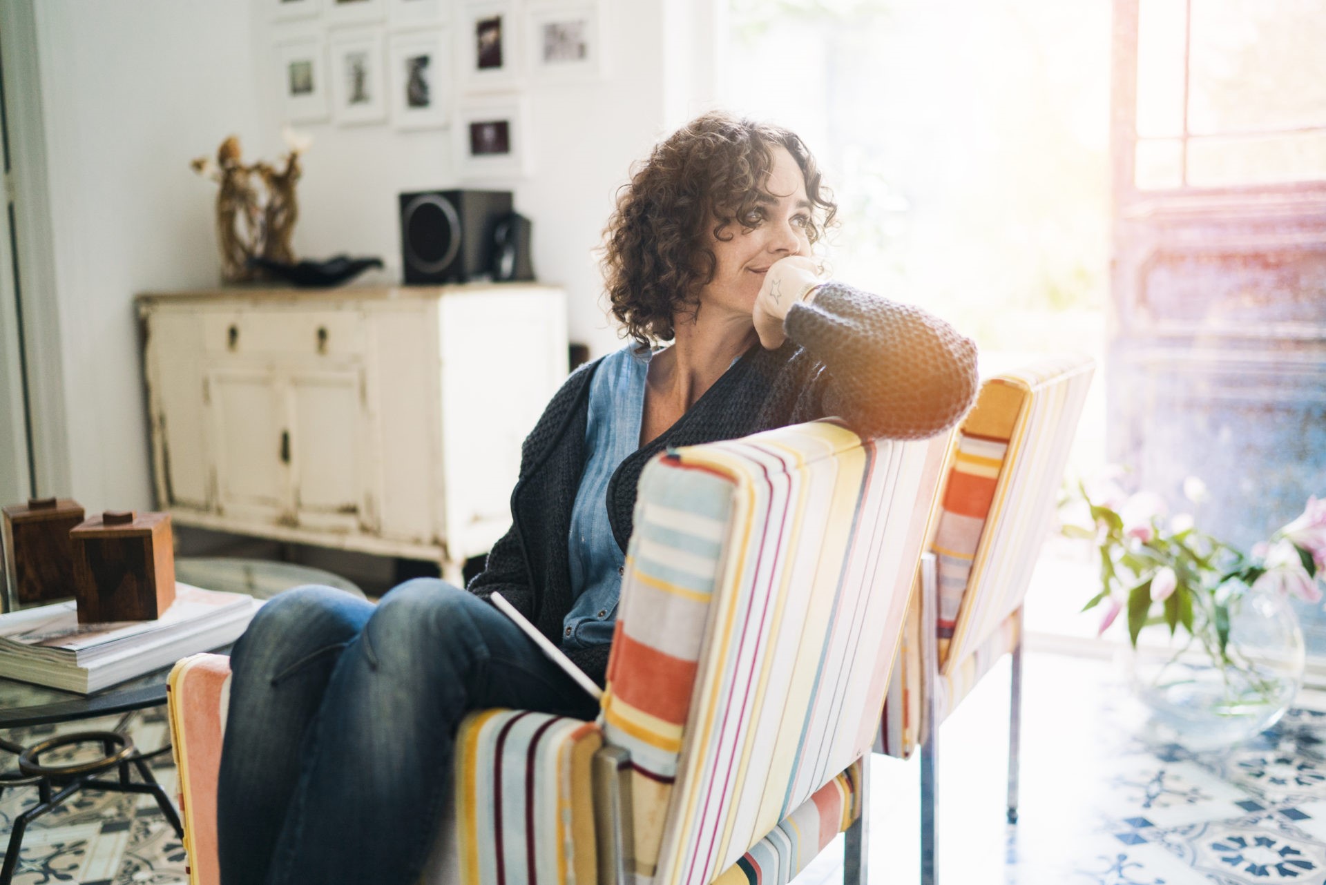 Thoughtful woman sitting on chair at home