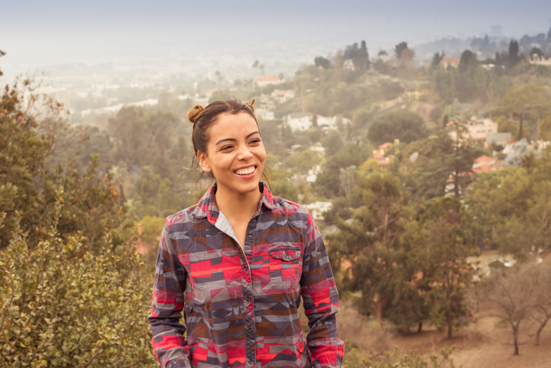 Latin woman smiles in front of landscape