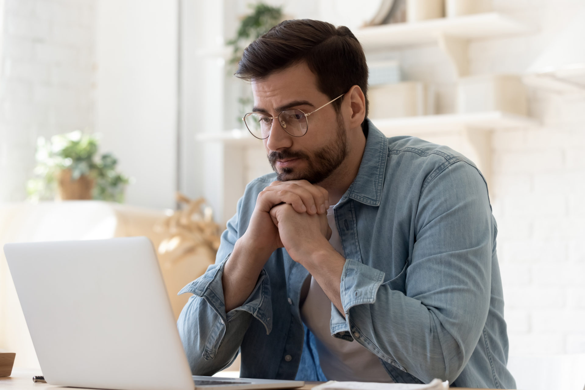 Pensive man work at laptop at home thinking