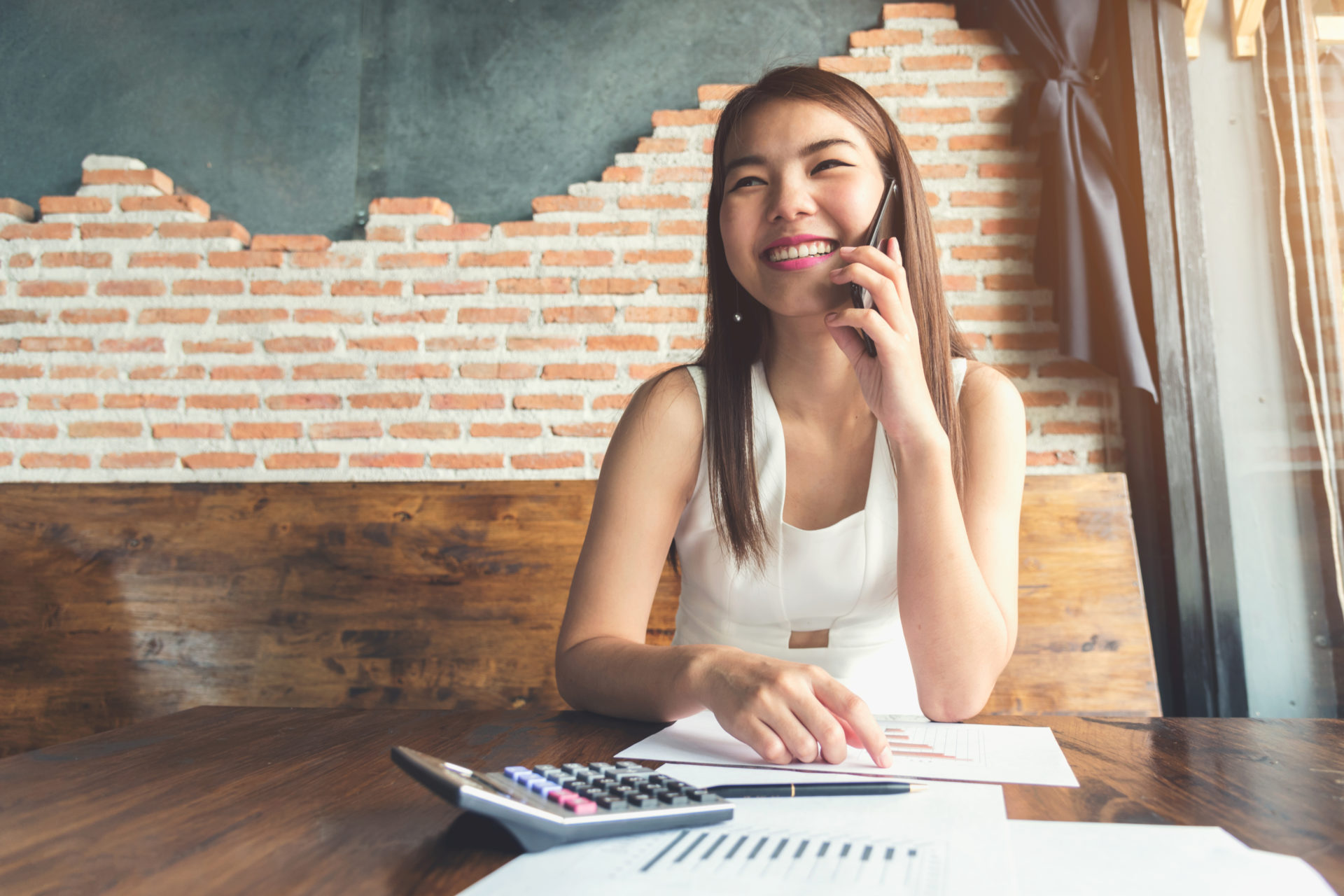 Beautiful business women call by smartphone in office.