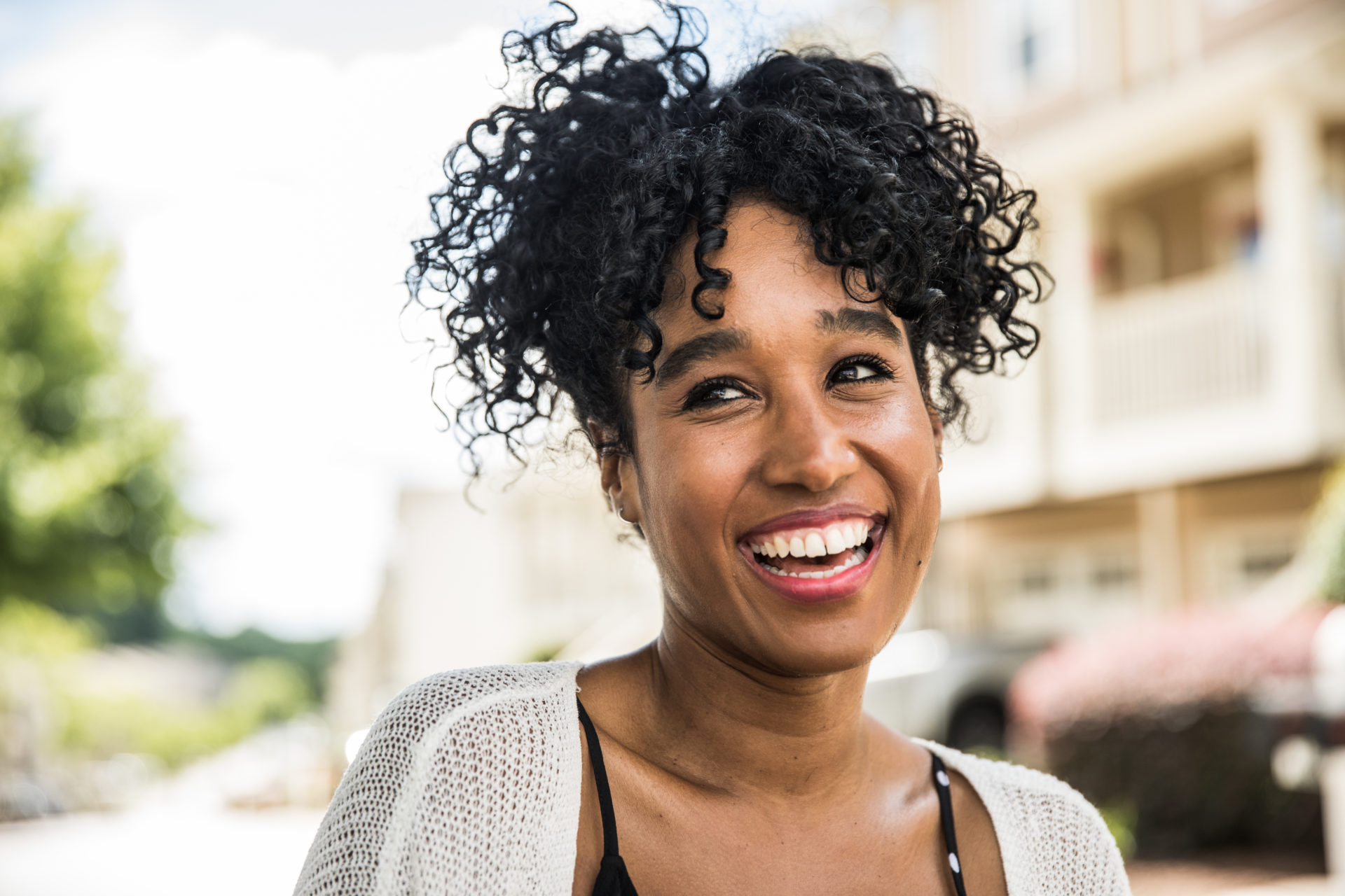 Portrait of young woman smiling in front of home