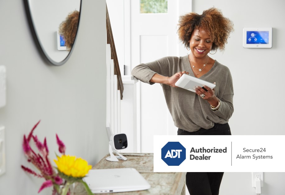 A black female securing her home with ADT, secure 24 alarm systems