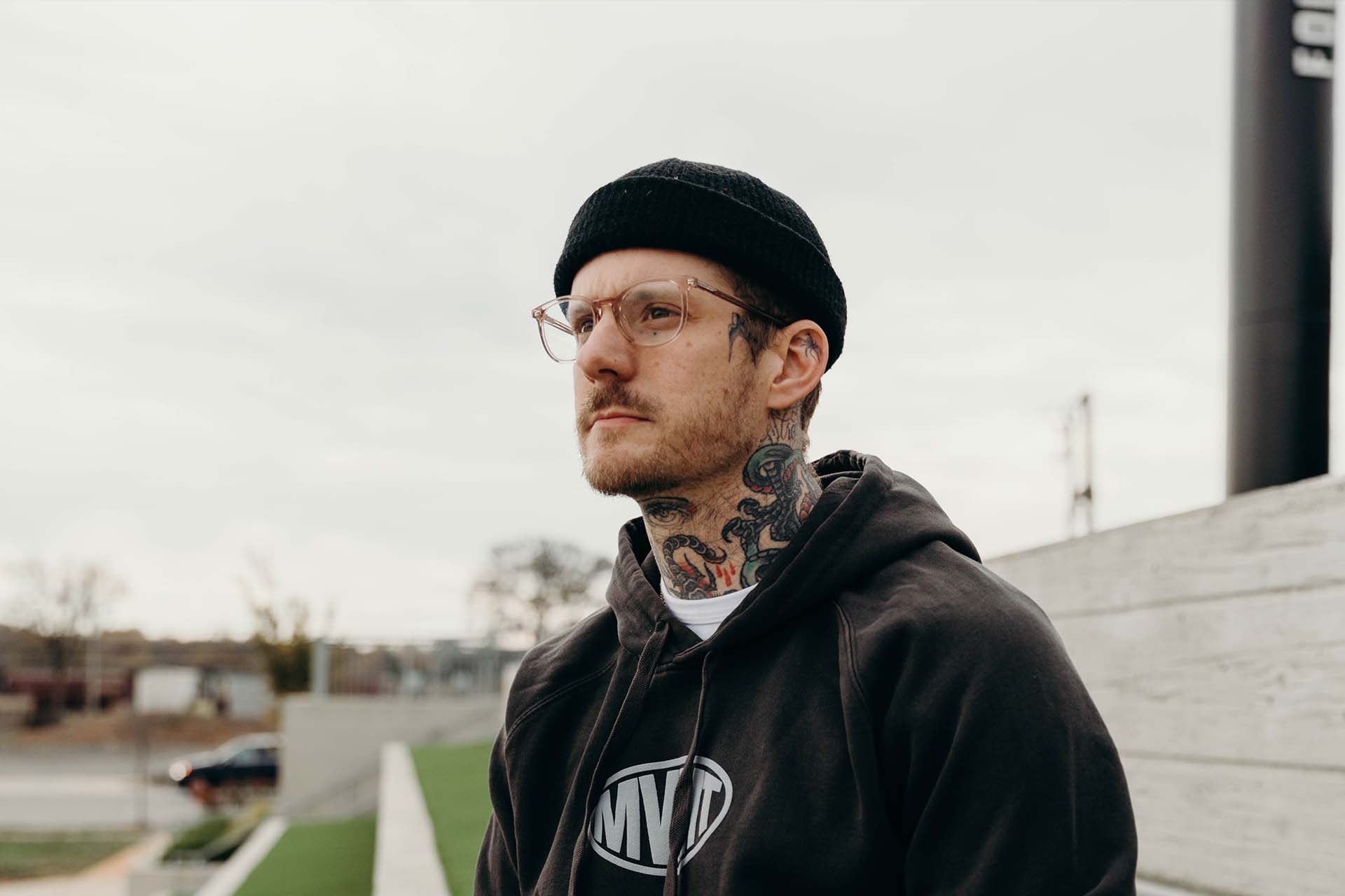 Man with neck tattoo wearing black Movement hoodie