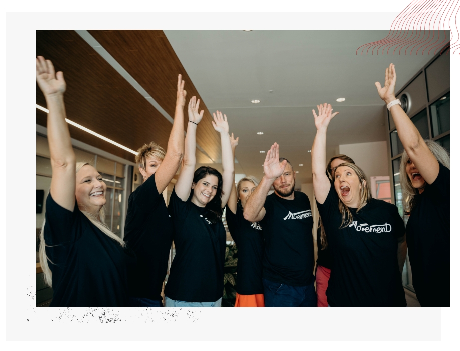 Group of people all wearing black shirts with arms raised in cheer