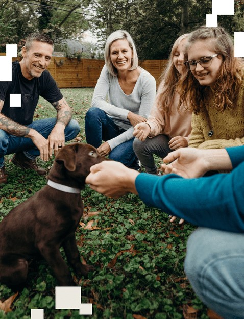 Family outside looking and playing with new puppy
